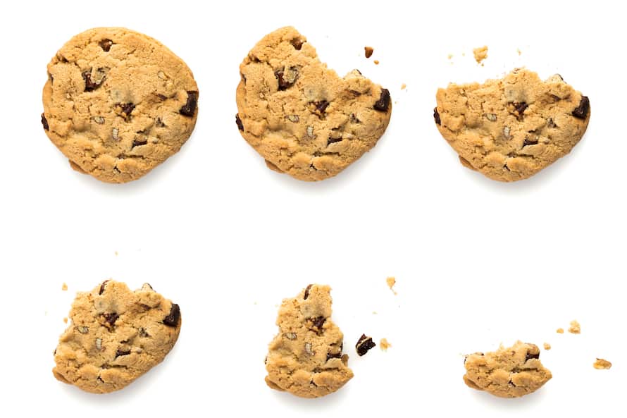 Six steps of chocolate chip cookie with pecan nuts being devoured. Sequence isolated on white background.